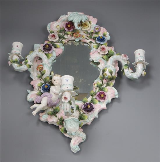 A floral encrusted porcelain three-branch wall mirror